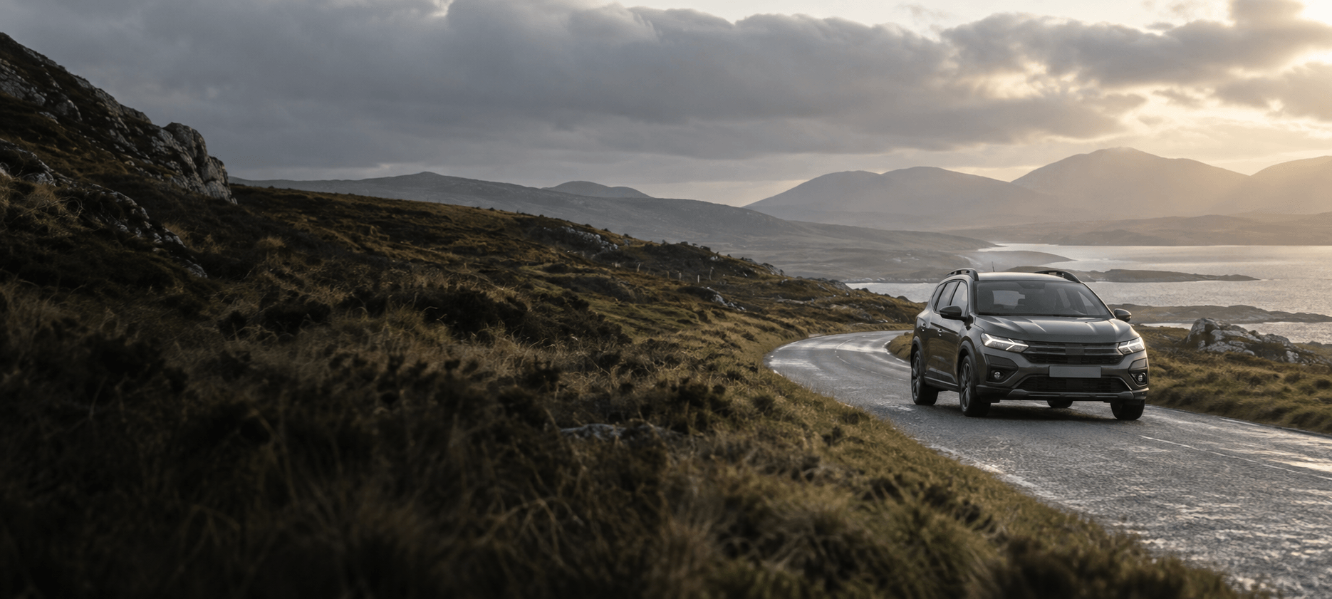 A vehicle travelling along a winding road through an Irish landscape